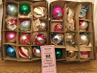Two cardboard boxes containing assorted vintage glass ornaments in individual compartments