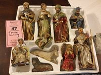 Full view of all nine pieces arranged in white styrofoam holder, showing variety of figures and animals included in the set.