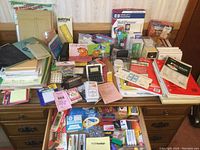 Overview photo of an extensive assortment of new and vintage desk supply items including folders, paper, index cards, stationery, calculators, and numerous smaller office tools.