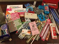 Photo showing assortment of crochet hooks, knitting needles, various notions, and instructional books.