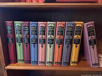 All ten Junior Classics volumes lined up on a wooden shelf, showcasing different colored spines and consistent vintage design.