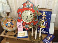 Wide view showing all items of the Swedish Christmas collection: painted wall clock, angel chimes, wooden folk art plate, and gold-tone decorative brooch in box.