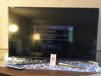 Front view of the Samsung 50-inch TV powered on displaying 'No Signal' on HDMI 1 input, showing screen condition and included TV stand.