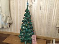 Full front view of 26" green ceramic tree with colored bulbs and star topper