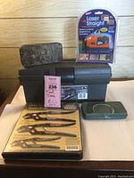 Photo showing black Craftsman tool box, Laser Straight laser level in packaging, vintage metal box, green metal socket set case, and unopened Craftsman Robo Grip pliers set.