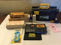 Full view of assorted tools, X-Acto blade sets, electric engraver, needle files, and tool box