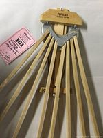 Photo showing entire drying rack with all 8 wooden arms fanning out, brand name visible on the wood block, metal hinges and folding mechanism evident.