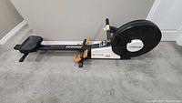 Side angled view of Johnson A3 Air System rowing machine showing full length, seat, and foot pedals