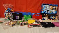 Full overview of all Playmobil sets, cases, and bags included in the lot arranged on a table.