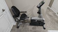 Side view of Schwinn 201 recumbent stationary exercise bike showing seat, pedals, and digital display.