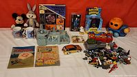Full lot overview showing plush toys, books, miniature toys, mugs and boxed items.