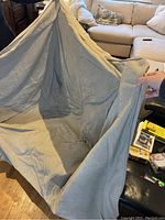 Taupe linen-like fabric arm chair cover held up showing size and texture.