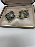 Pair of rectangular cufflinks featuring lucite and mother of pearl with a central pearl, shown in Stetson box.