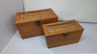 Two wooden storage boxes with lattice tops shown together for size comparison