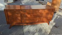 Front view of credenza with tambour doors closed and four central drawers.
