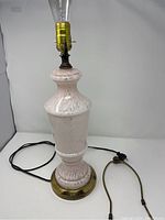 Full view of vintage pink glass table lamp with bronze base, showing power cord and bulb socket.