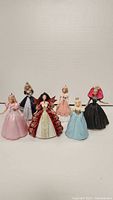 Front view of all six Barbie Christmas ornaments, showing details of each doll's gown and design.