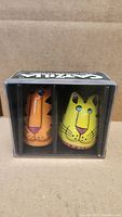 Photo of sealed Catzilla salt and pepper shakers in original clear plastic box showing orange and yellow cat designs