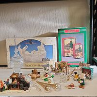 Overall view of a group of vintage Christmas figurines and musical decorations arranged on a textured surface under indoor lighting