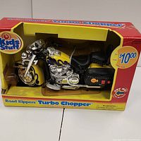 Front side view of boxed yellow and black Road Rippers Turbo Chopper motorcycle toy with flame design and chrome detailing.