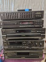Stack of Technics home stereo components including equalizer, CD player, 5-disc changer, receiver, and cassette deck