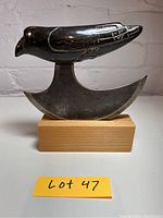 Front view of scraper showing metal blade and carved bird handle