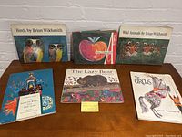 Photo of six children's books by Brian Wildsmith arranged on a surface, showing front covers with colorful illustrations of animals and themes.
