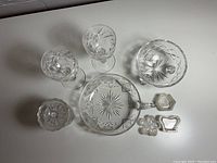 Assorted crystal glassware and decorative items shown from above on white background