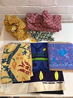 Full view of assorted fabric pieces showing various floral and geometric prints including the large Marimekko fabric and smaller floral off cuts