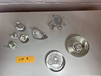 Top-down view of the lot showing all glass figurines and paperweights on a white surface with a Lot 9 label.
