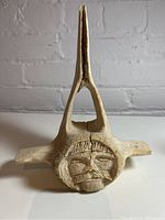 Front view of carved antler showing face motif