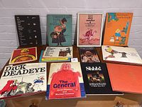 Photo of 12 children's books from the 60s and 70s arranged on a table showing colorful and illustrated covers.