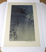 Lithograph laid flat on white portfolio folder displaying full image and signature lower right