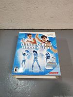 Front view of Dance Dance Revolution Wii Dance Mat original box with product name and dancing figures in blue and white theme.