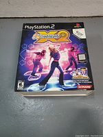 Boxed PlayStation 2 Dance Dance Revolution X2 game showing Konami branding and ESRB rating.