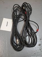 Two black XLR cables coiled, noted length of 25 feet each, secured with cable ties, placed together on floor.