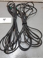 Two coiled black XLR cables laid out on the floor, showing length and overall look.
