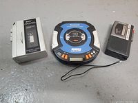 Front view of the three devices on tabletop: cassette player, Panasonic CD player, Sony microcassette recorder connected by wire to remote microphone/recorder part