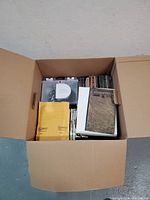 Cardboard box filled with discs and cases