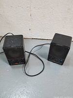 Photo showing two black Fostex 6301B personal monitor speakers side by side with cables and metal front grills.