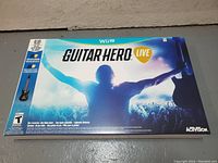 Front packaging of Guitar Hero Live for Wii U showing game title and concert stage scene with guitarist silhouette.