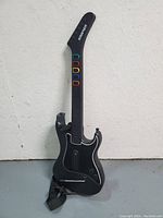 Front view of Kramer Guitar Hero 3 wireless guitar controller showing colored fret buttons and strap.