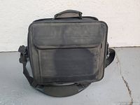 Front view of black Targus laptop bag showing top carry handle, front flap pocket, and main compartment.