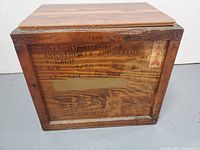 Side view of the wooden crate showing original anesthesia apparatus markings and wood stain finish.