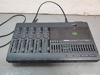 Front view showing four channel faders, level and pan knobs, master control, 10-band EQ, transport buttons and cassette compartment.