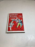 Front cover of the book Dorothy and the Wizard in Oz by L. Frank Baum, showing Dorothy and the Wizard illustration on a red background.