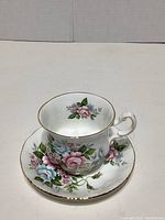 Photo showing the bone china teacup and saucer with hand painted Flower Festival F pattern floral design and gold trim.