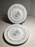 Front view of two 8-inch plates with blue rose and silver edge design, showing scalloped rims and floral pattern.