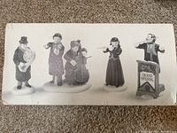 Front view of porcelain figurine set displayed in original box.