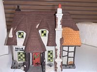 Front side view of Dept 56 Maylie Cottage collectible ceramic house showing detailed roof, windows, chimney, and front door with wreath.